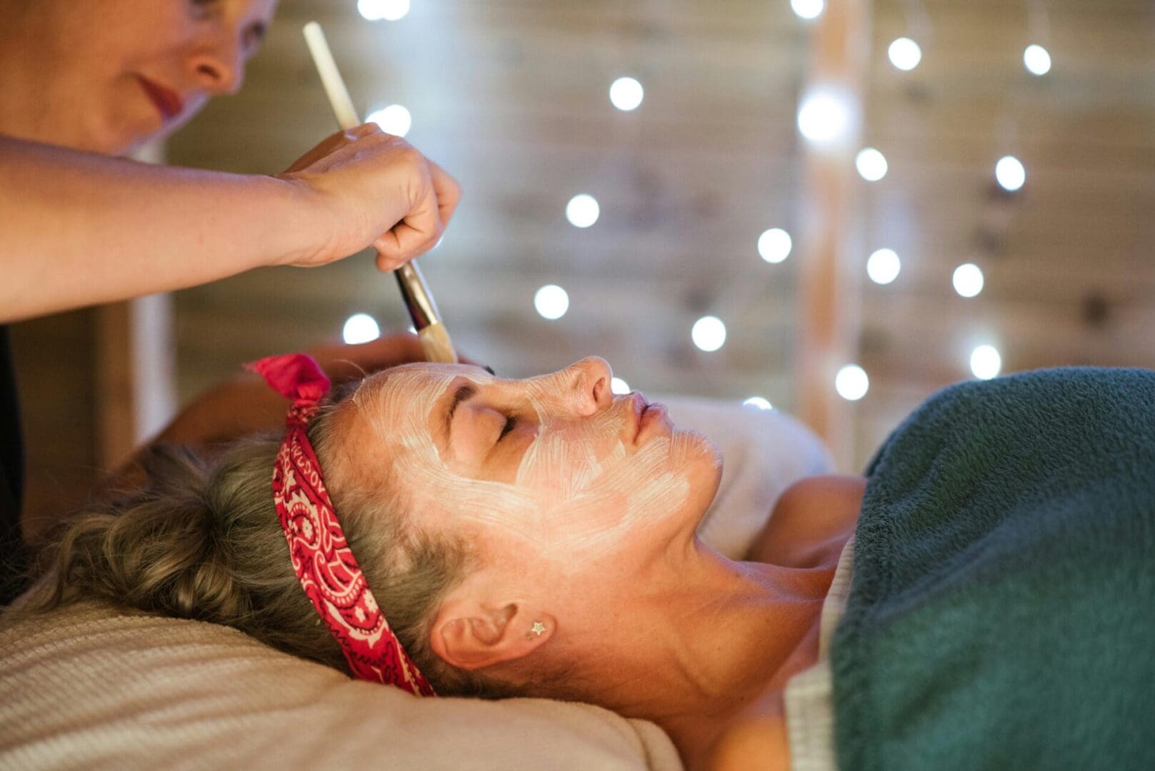 A practitioner applies a skin treatment with a brush
